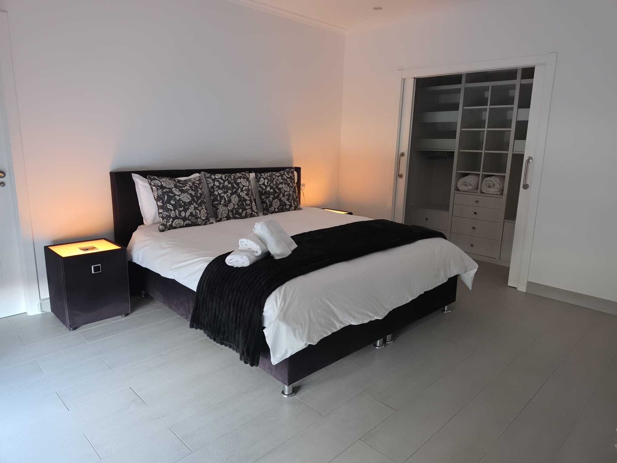 Une chambre à coucher moderne, avec un lit, des tables de chevet et une armoire.