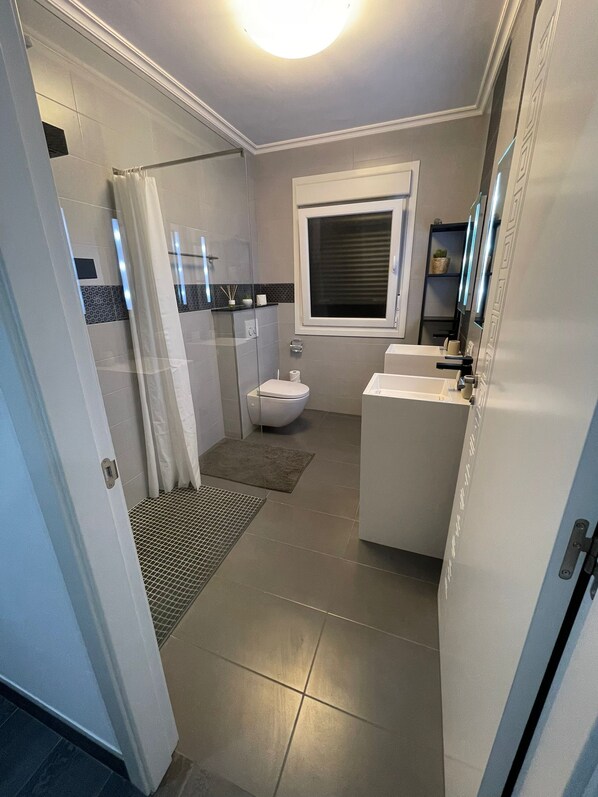 A compact bathroom with a shower, toilet, and sink.