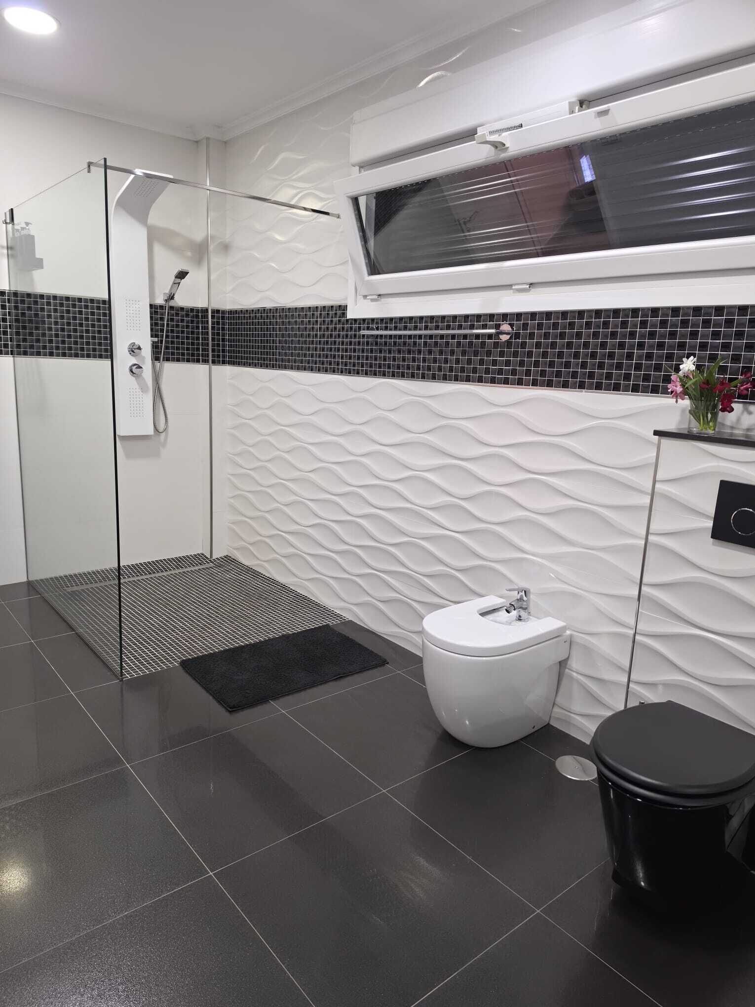 A modern bathroom with a shower, toilet, and bidet.