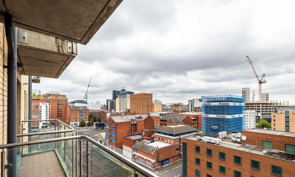 A cityscape with various buildings, including a construction site with a blue facade.