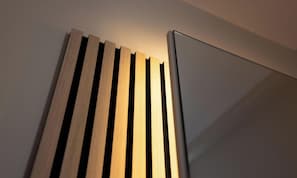 Ein modernes, minimalistisches Zimmer mit einer horizontalen Wandgestaltung und einer eleganten, weißen Schranke.