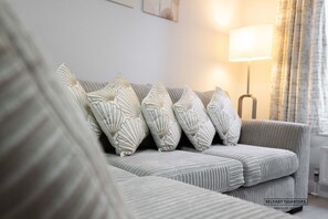 A living room with a sofa, patterned cushions, a floor lamp, and a window with curtains. - Belfast Quarters Lower Windsor (Belfast)