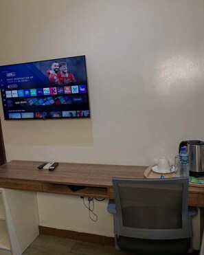 Televisor de pantalla plana montado en la pared que muestra un canal deportivo y varios iconos de aplicaciones.