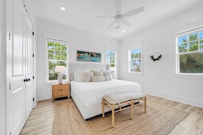 A bedroom with a bed, bedside tables, a ceiling fan, and large windows. - Lovely Day 30a by Stay on 30a (Inlet Beach)