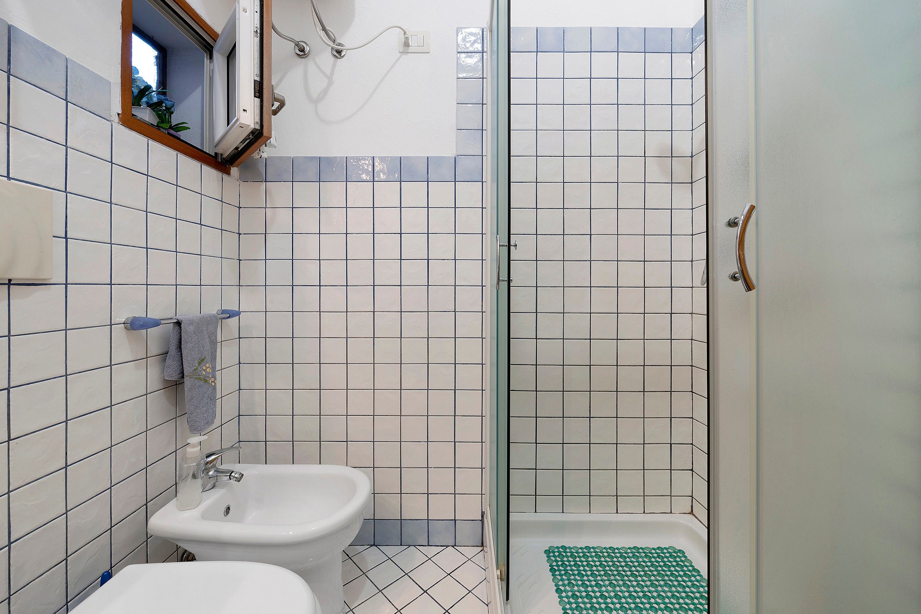Une salle de bain avec une douche, deux lavabos et des toilettes.