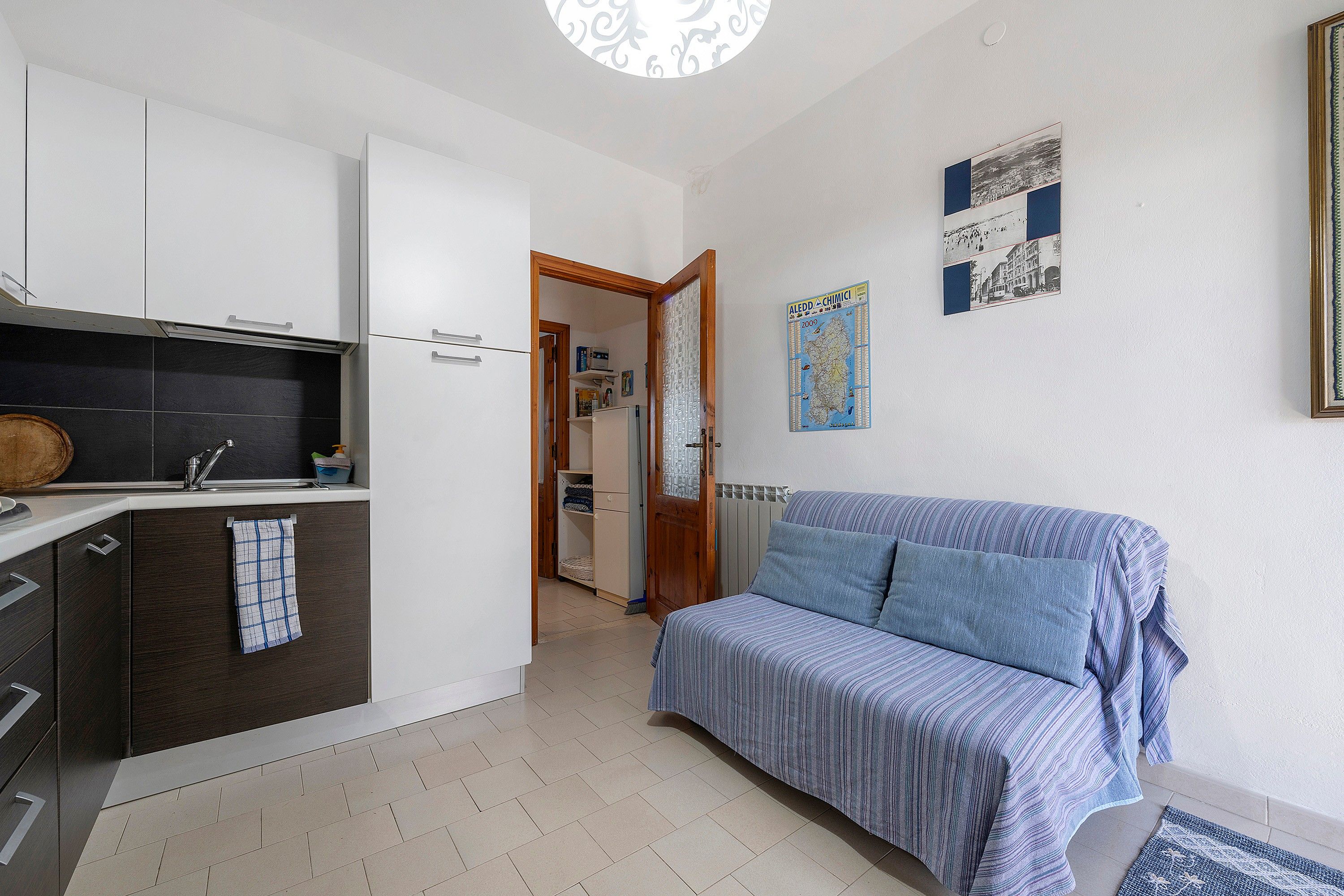 Een knus woongedeelte met een kitchenette, een bank en een eethoek.