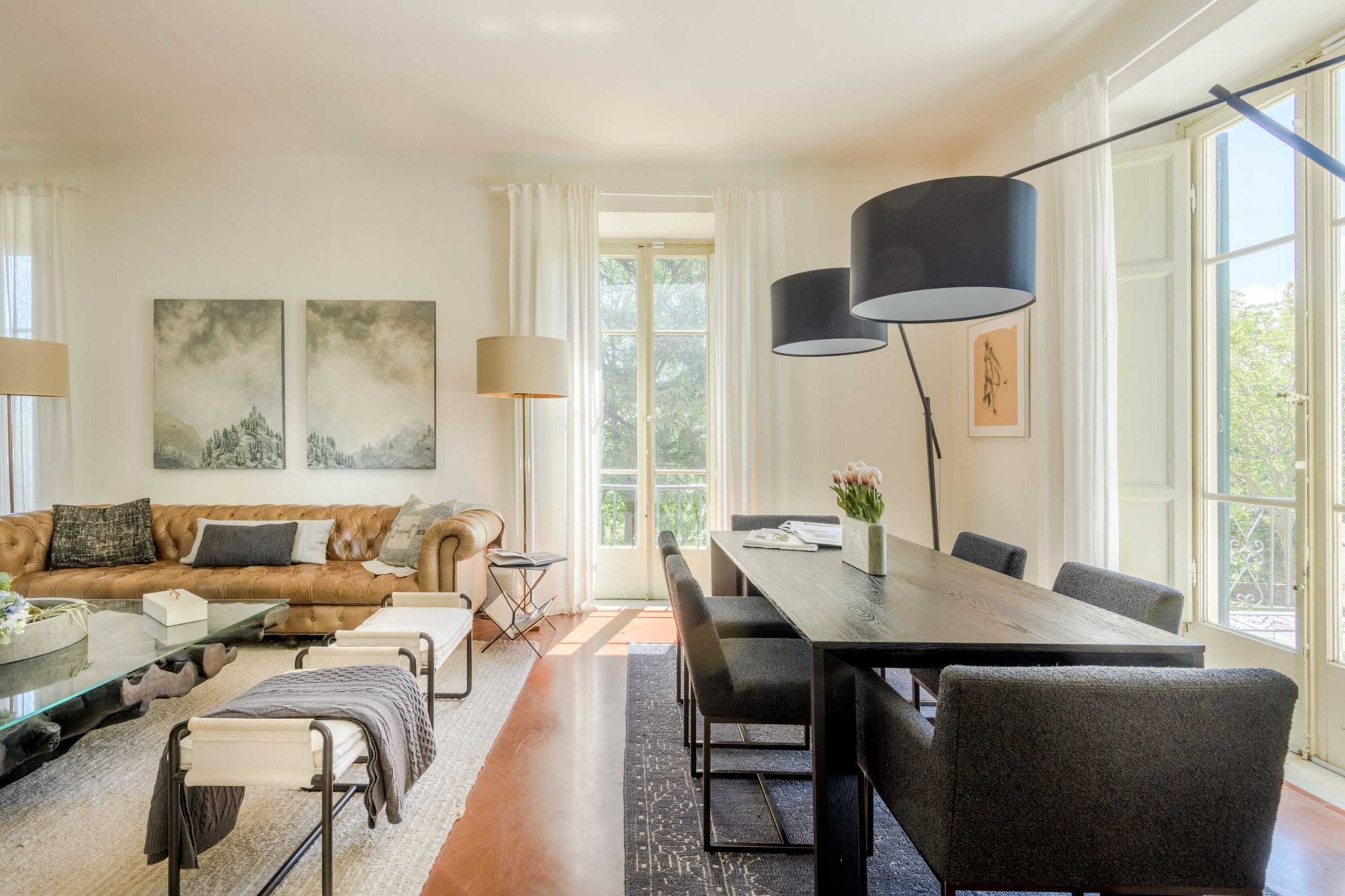 A modern living room with a sofa, coffee table, and dining area.
