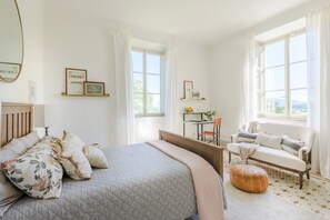 A bedroom with a bed, a sofa, a desk, and a window with curtains. - Villa Bertolli in Lucca (Lucca)