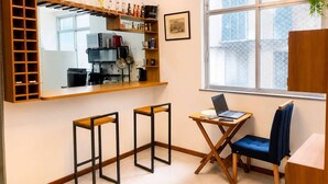 Una cocina compacta con barra, una mesa de comedor con sillas y un ventanal con vistas.