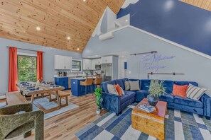 A modern interior with a dining area, kitchen, and living space. - Sauna •  Hot Tub • Game Room • Theater •  Firepit (Bethel)