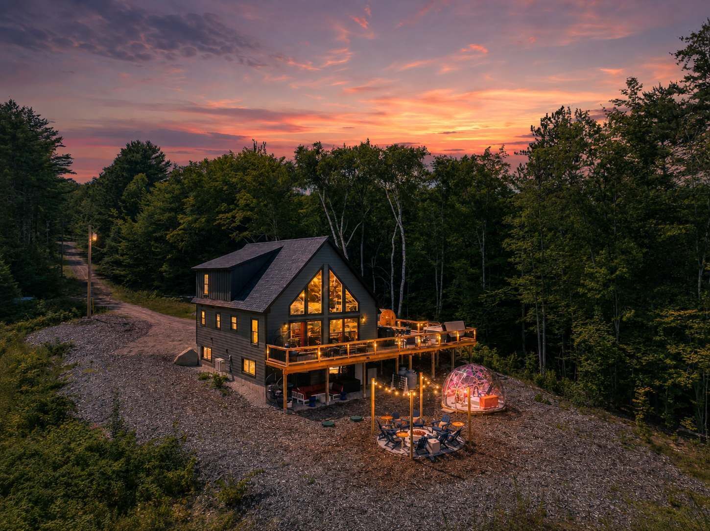 Een chalet met een ruim terras, een overdekte zithoek en uitzicht op het omliggende bos.