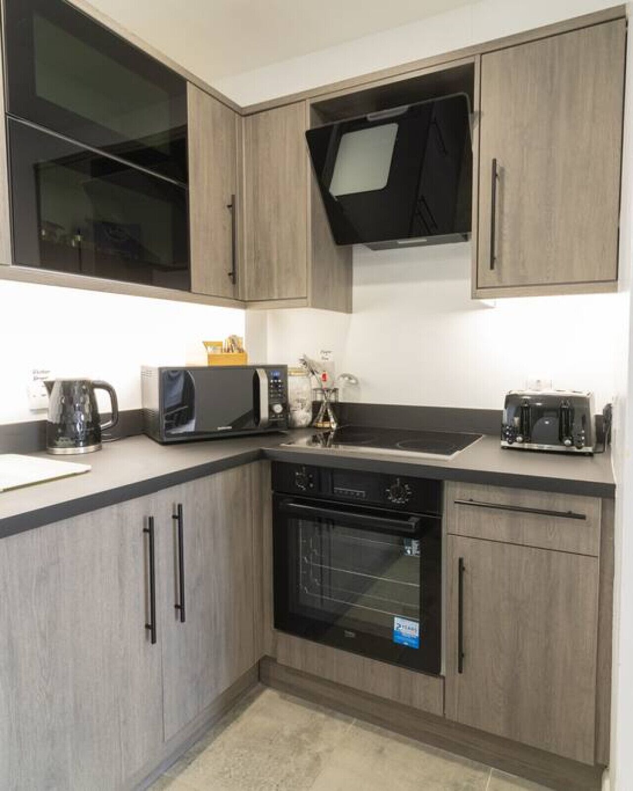 A compact kitchen with a microwave, toaster, and oven.