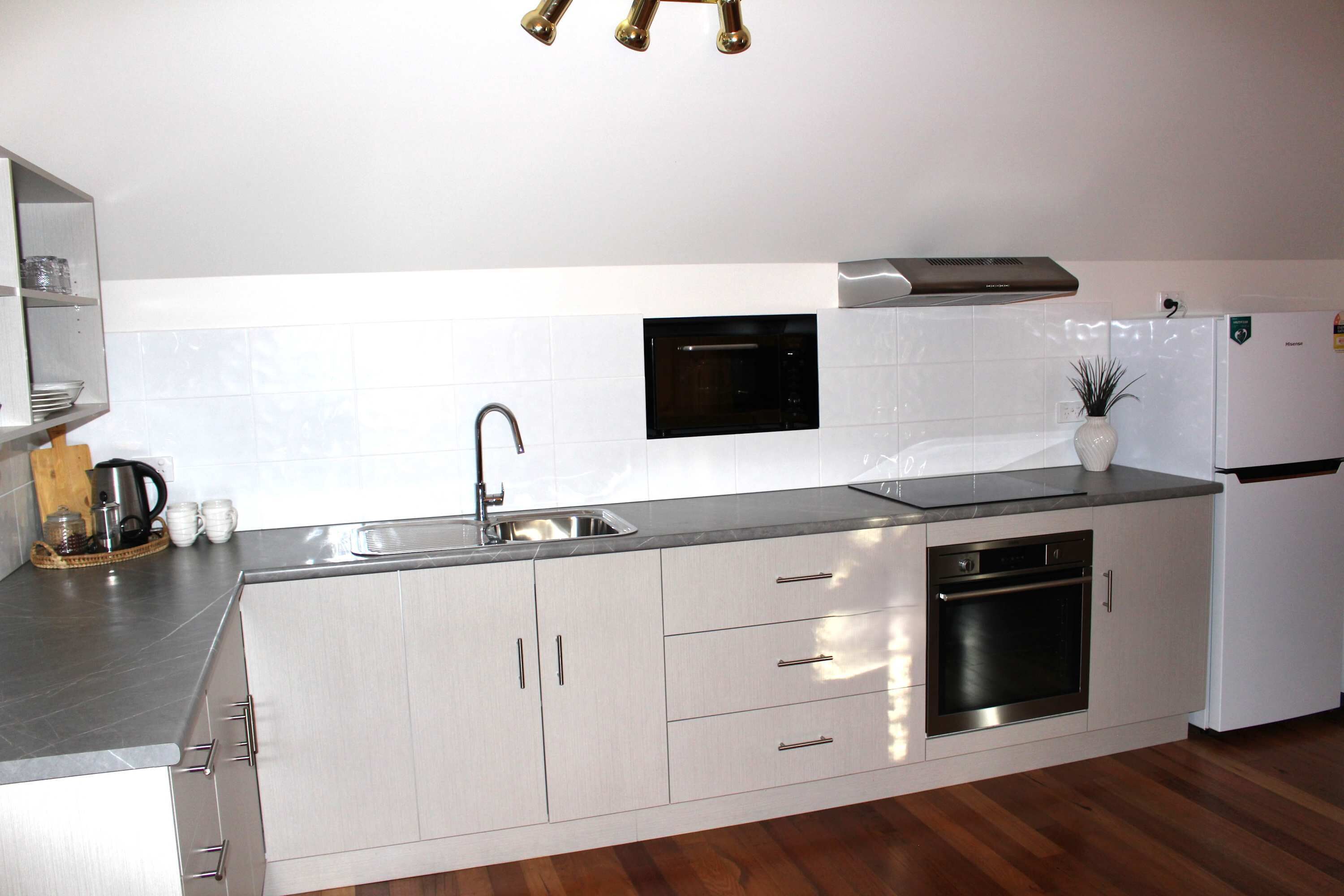 A modern kitchen with stainless steel appliances, a built-in oven, and a sink.