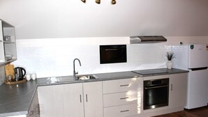 A modern kitchen with stainless steel appliances, a built-in oven, and a sink. - Villa Marche - Taste of Tuscany (Riverside)
