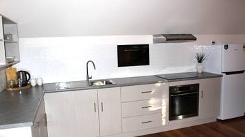 A modern kitchen with stainless steel appliances, a built-in oven, and a sink.
