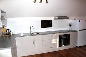 A modern kitchen with stainless steel appliances, a built-in oven, and a sink.