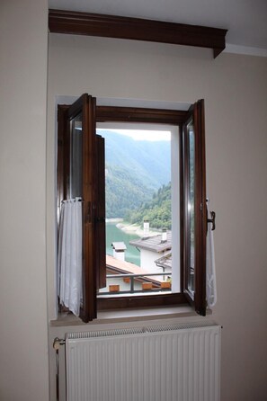 A room with a window overlooking a river and mountains. - BELVEDERE LAKE VIEW VACATION RENTAL (Rocca)