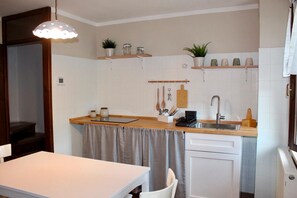 A compact kitchen with a wooden countertop, a sink, and a small dining area. - BELVEDERE LAKE VIEW VACATION RENTAL (Rocca)