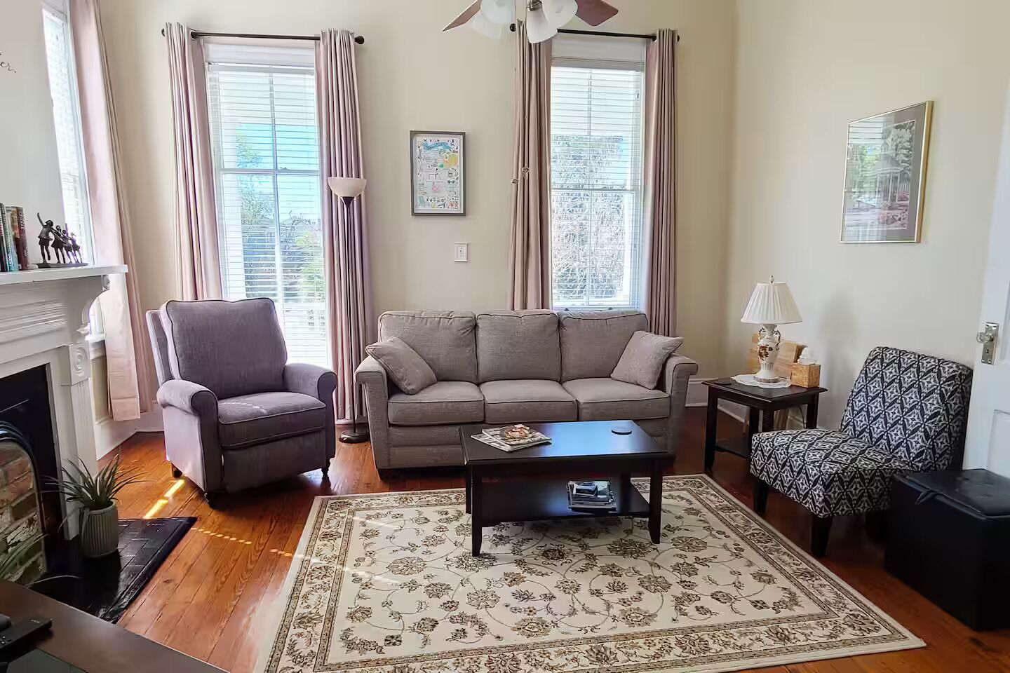 A living room with a fireplace, two sofas, a coffee table, and a patterned rug.