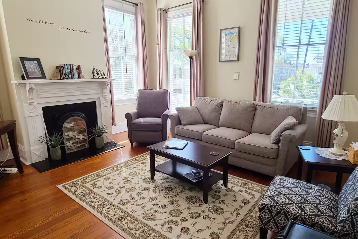 Een woonkamer met een open haard, een bank, een salontafel en een kamerbreed tapijt.