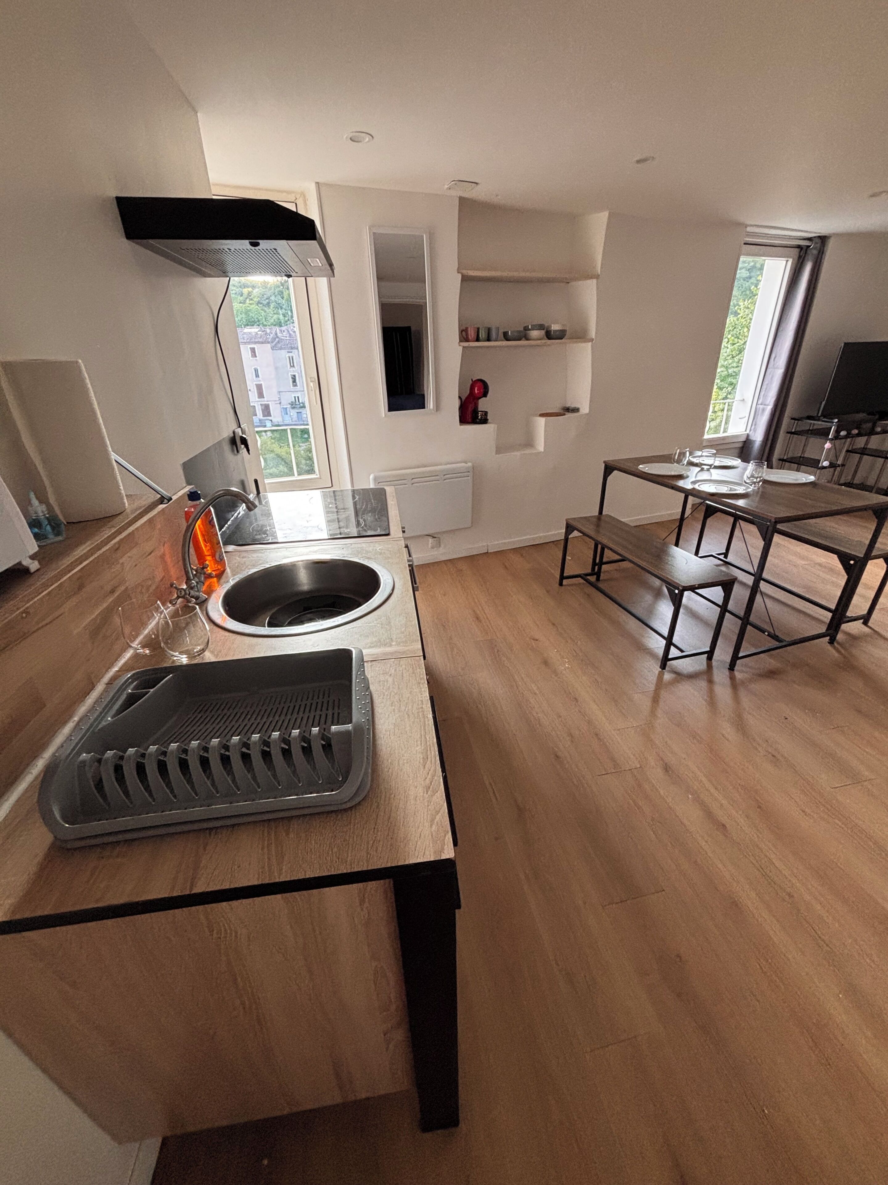 Una cucina moderna con forno integrato, lavello e zona pranzo con tavolo e panche.