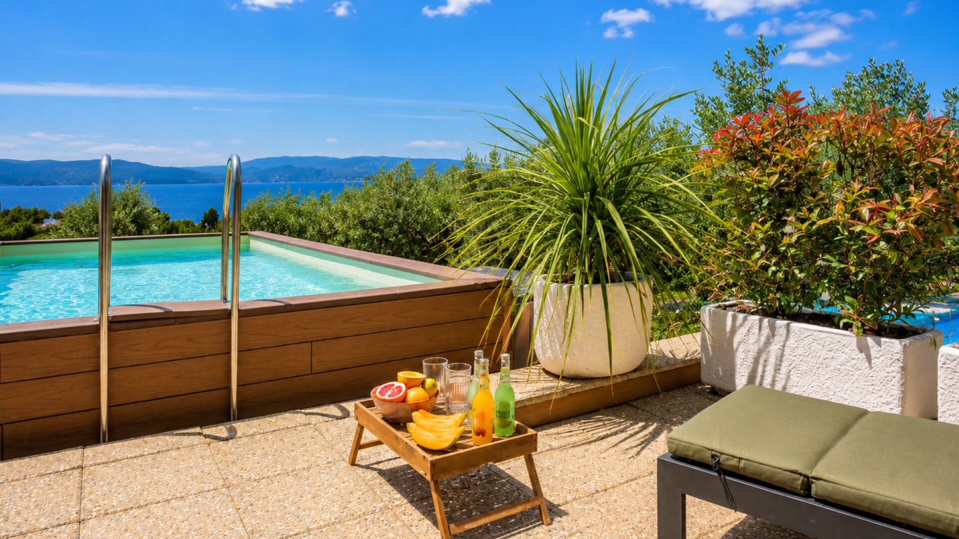 Ein Pool auf dem Dach mit Holzterrasse, Liegestuhl und Obsttablett.