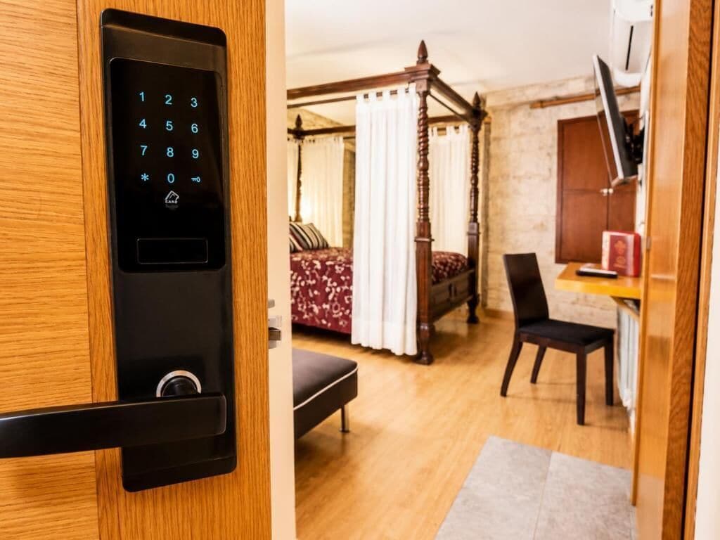 Una habitación con cama con dosel, un escritorio con silla y un moderno sistema de cierre.