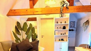 Een gezellige kamer met een bed, een klein tafeltje en een kitchenette.