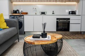 Eine moderne Küche mit weißen Schränken, einem Backofen und einer Kaffeemaschine.