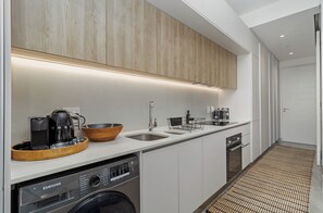 A modern kitchen with a built-in washer, a coffee maker, and a sink. - Skyline Retreat | Heart of Cape Town (Cape Town)