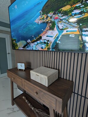 A television mounted on a wall displaying a coastal town view. - 2-bedroom with JACUZZI and WATER BACKUP in charming Carolina (Carolina)