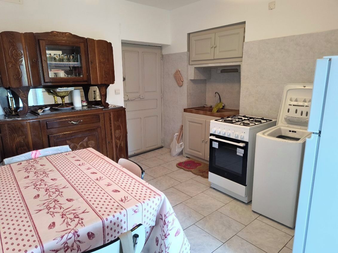 Une cuisine de taille réduite équipée d’une cuisinière à gaz, d’un four et d’un réfrigérateur.