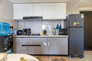 A modern kitchen with a built-in stove, a refrigerator, and a coffee maker. - The Safari view Gateway | 10 Min JKIA | 5 Min SGR (Nairobi)
