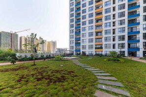 A residential building with multiple balconies, a well-maintained lawn, and a construction crane in the background. - The Safari view Gateway | 10 Min JKIA | 5 Min SGR (Nairobi)
