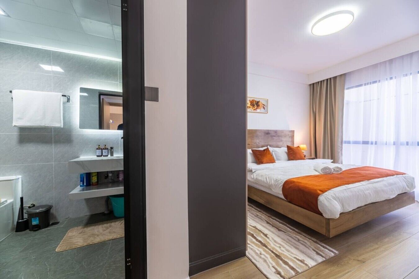 Quarto de hotel moderno com cama, banheiro e vista para a cidade.