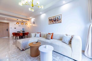 A modern living room with a sofa, coffee table, and pendant lights. - Azure Luxe Residence (Nairobi)