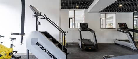 A gym with a stair climber, treadmills, and a stationary bike.