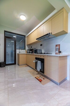 A modern kitchen with a built-in oven, a microwave, and a gas stove. - Azure Luxe Residence (Nairobi)
