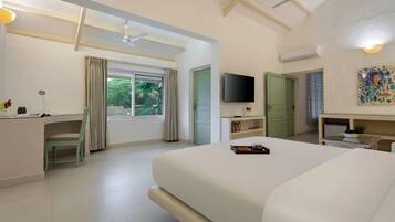 A hotel room with a bed, a desk, a chair, a television, and a window with curtains.