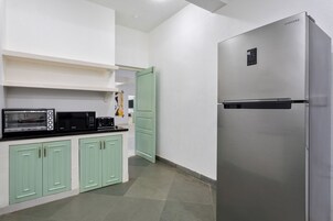 Una cocina con un refrigerador de acero inoxidable, un microondas y una tostadora.