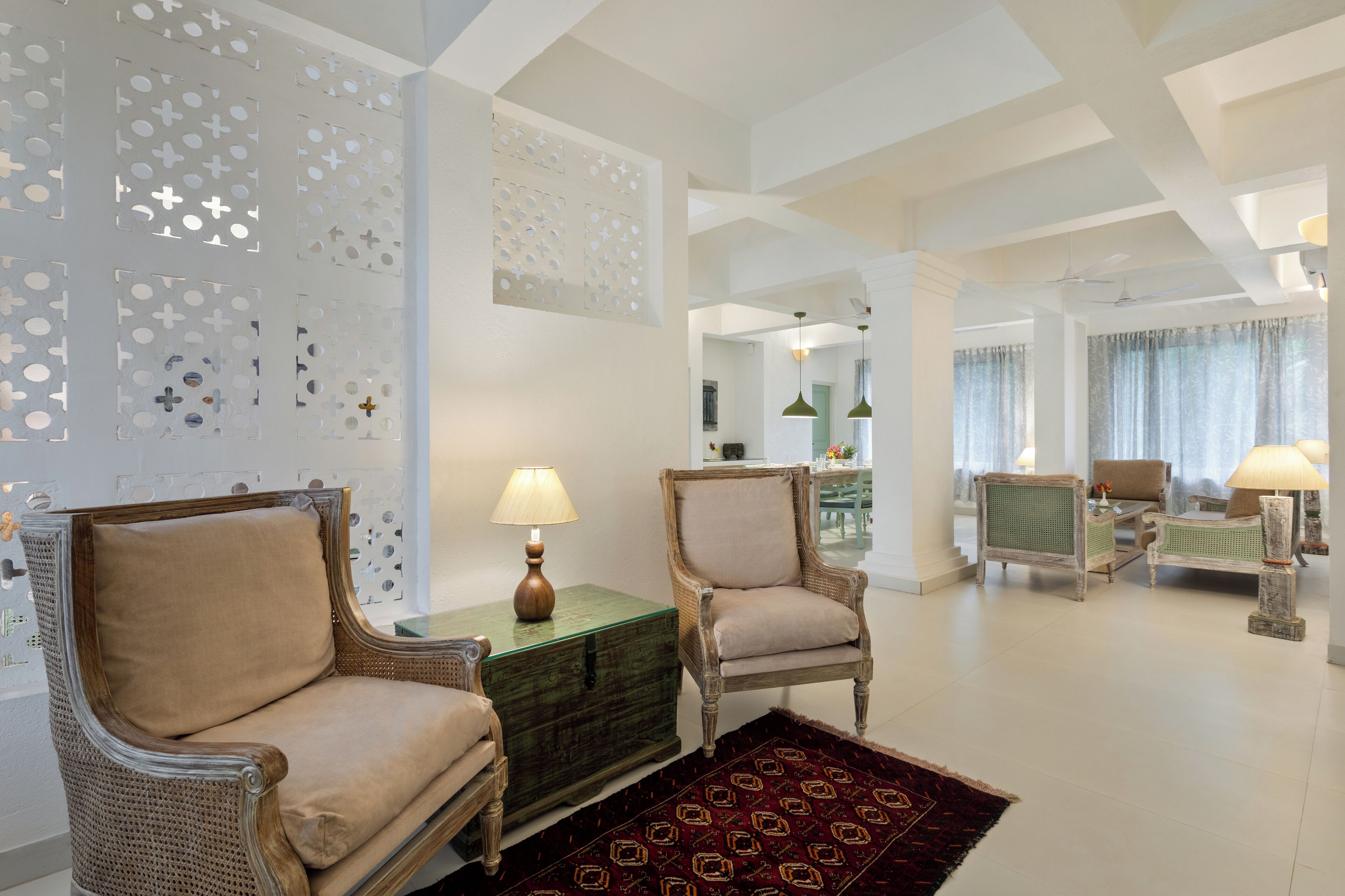 A spacious living room with two armchairs, a coffee table, and a patterned rug.