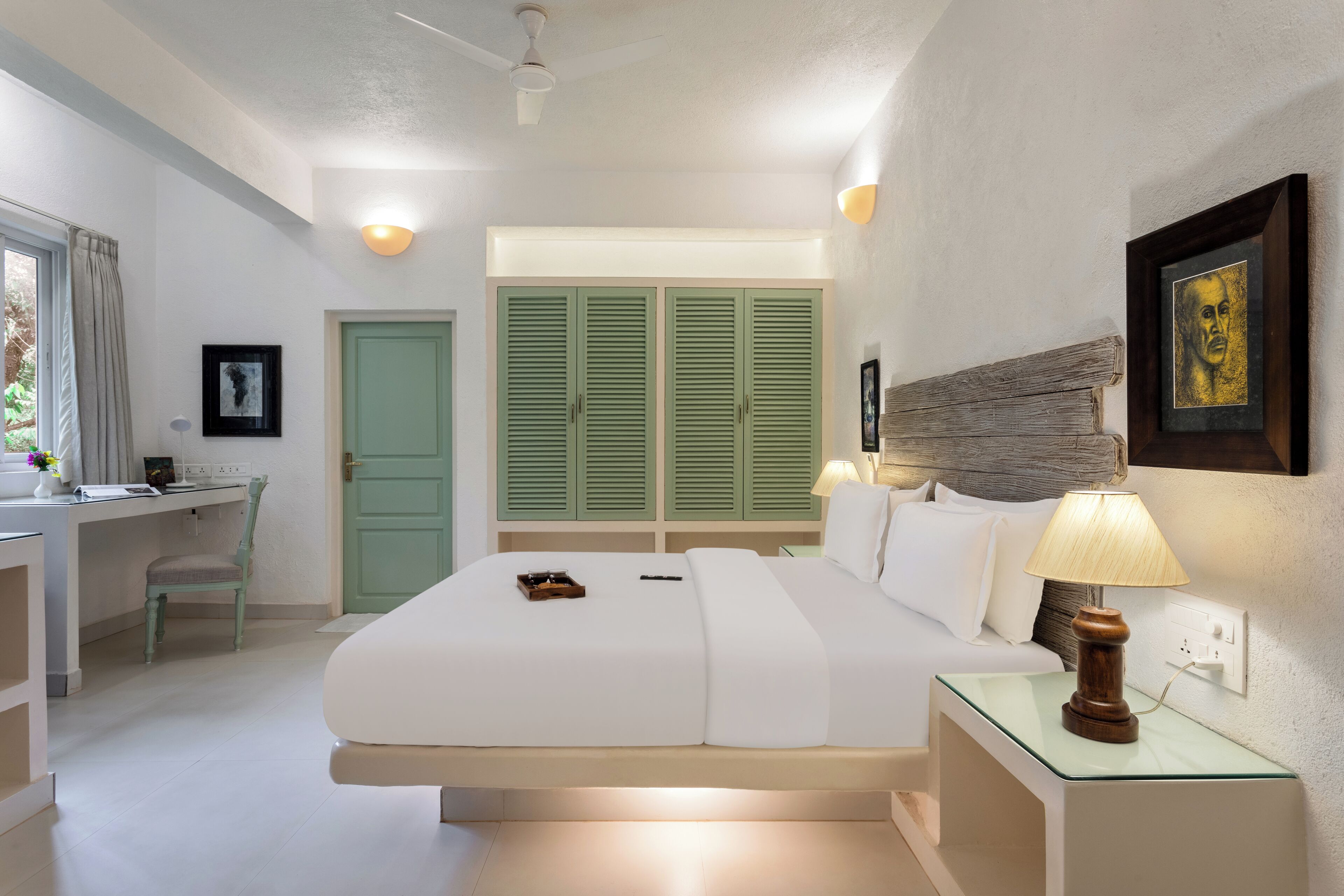 Una habitación de hotel con cama, mesitas de noche, escritorio y armario.