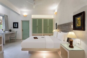 A hotel room with a bed, bedside tables, a desk, and a wardrobe. - Aroha Palm Grande (Marra)