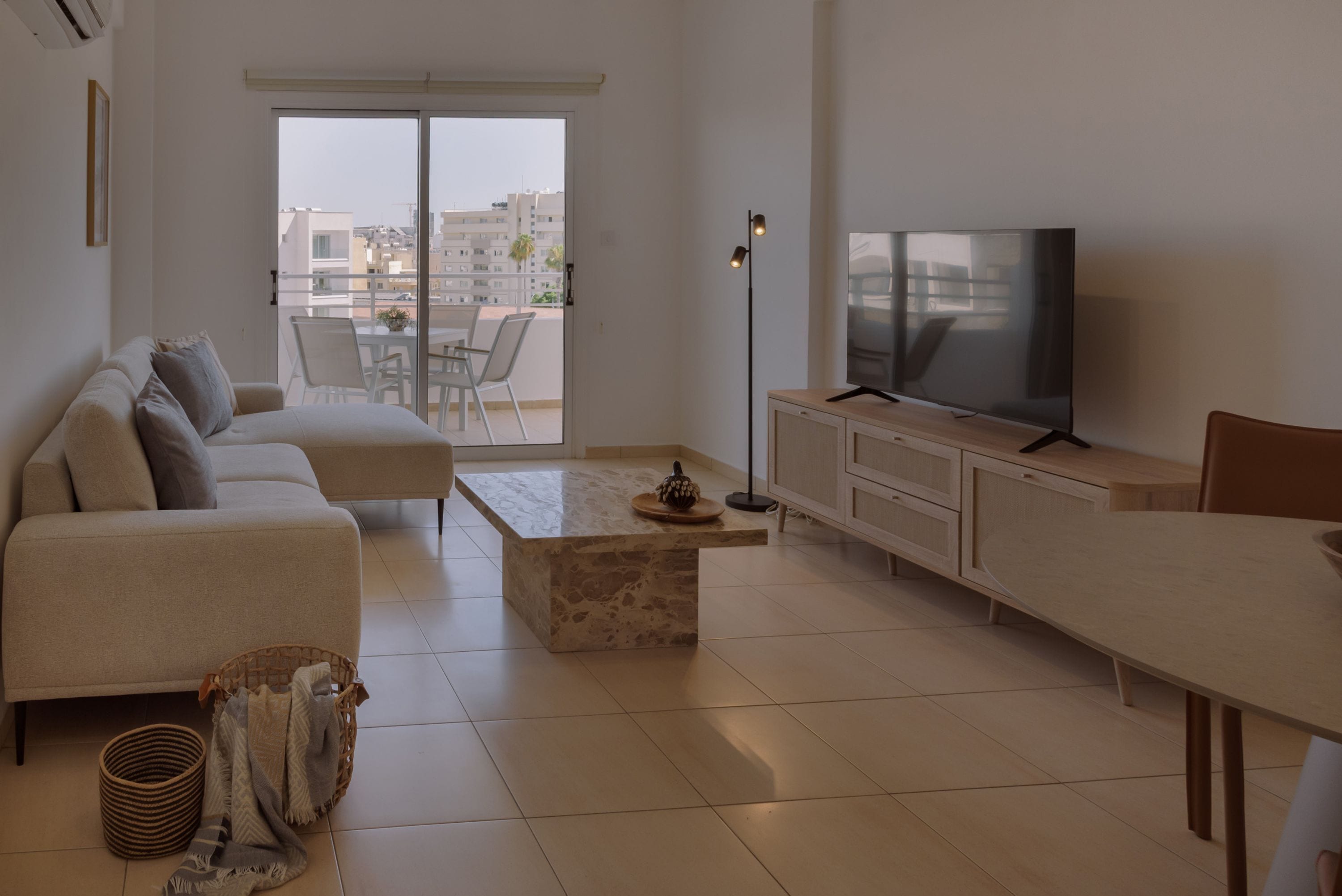 Una sala de estar moderna con un sofá, una mesa de centro, un televisor y un comedor.