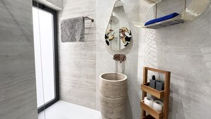 A modern bathroom with a large mirror, a round sink, and a wooden shelf with toiletries. - 155 PRO - Stay Prime View Apartment (Paralimni)