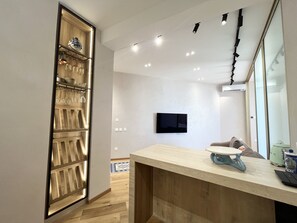 A modern kitchen with a wooden cabinet, a countertop, and a television mounted on the wall. - 155 PRO - Stay Prime View Apartment (Paralimni)