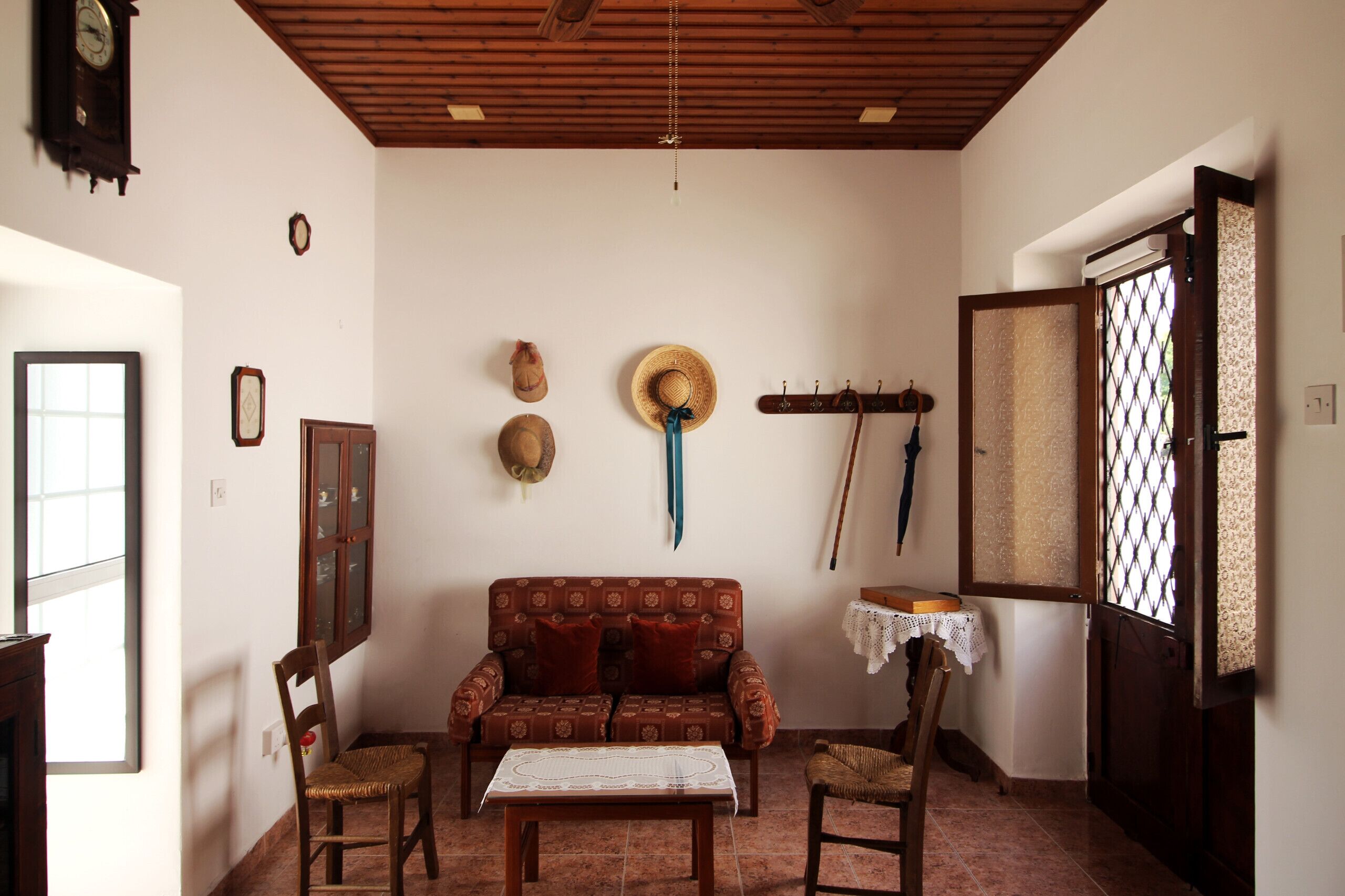Una sala acogedora con un sofá, sillas, una mesa y techo de madera.