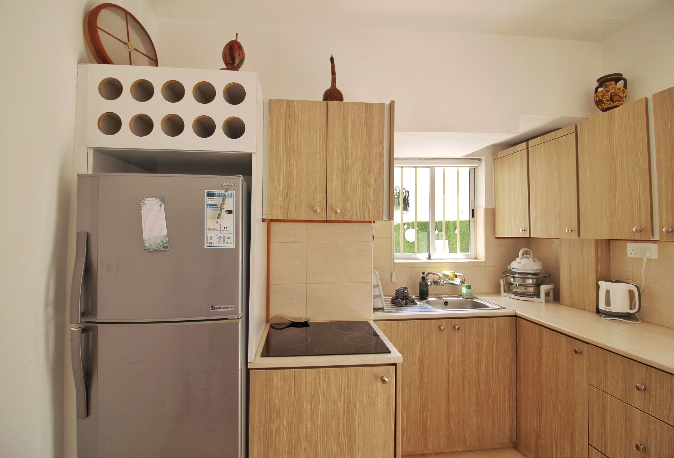Una cocina compacta con refrigerador integrado, estufa y armarios de madera.