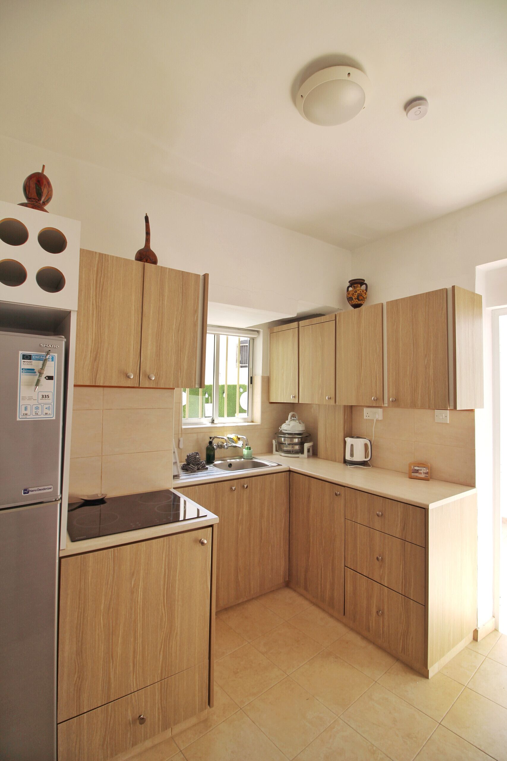 Una cocina moderna con armarios de madera, horno empotrado y refrigerador de acero inoxidable.