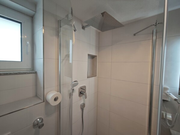 A bathroom with a glass shower enclosure, a toilet, and a bidet. - Vrbo Property (Reutlingen)